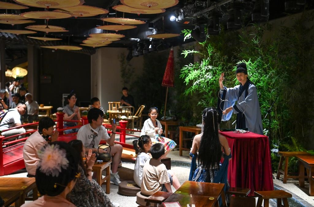 游客在長安十二時辰主題街區(qū)觀看唐風(fēng)演藝《大唐曲藝》。新華社記者鄒競一 攝