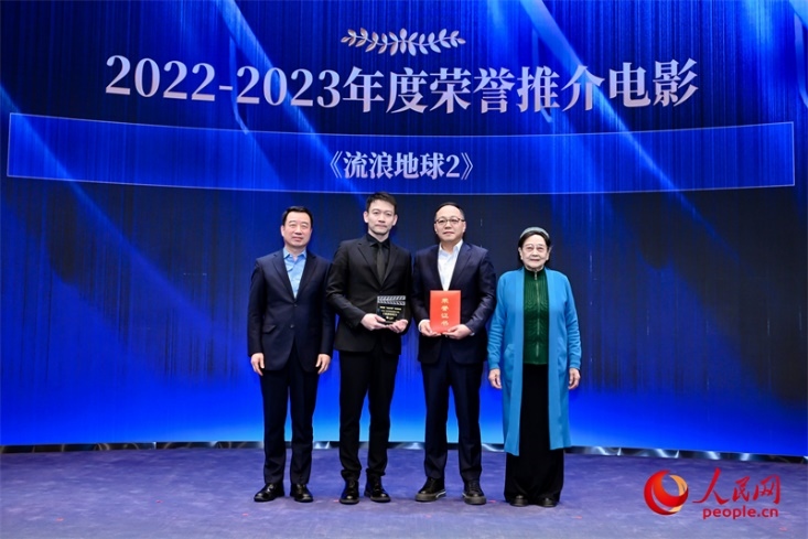 著名電影藝術(shù)家、事業(yè)家王曉棠（右一）和中國文聯(lián)書記處書記張宏（左一）為《流浪地球2》出品人、總監(jiān)制、總制片人傅若清（右二）與導(dǎo)演郭帆（左二）頒發(fā)“2022-2023年度榮譽推介電影”