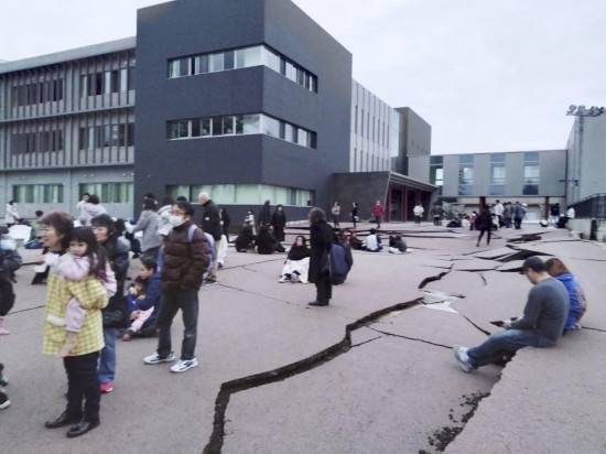  1月1日，在日本石川縣輪島市，人們站在被地震破壞的地面上。新華社/共同社