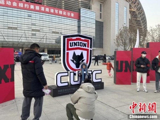 球迷們與隊(duì)徽合影。記者 卞立群 攝