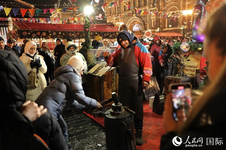 游客在新年集市上體驗制作紀念幣。人民網(wǎng)記者 隋鑫攝