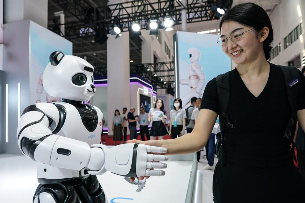 2023年8月16日，一名女士在北京舉辦的2023世界機(jī)器人大會(huì)現(xiàn)場(chǎng)與智能機(jī)器人握手。新華社記者彭子洋攝