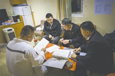 圖②：法官向船長(zhǎng)講解相關(guān)法律規(guī)定，查看船舶資料，并與船方辦理扣押船舶的手續(xù)。