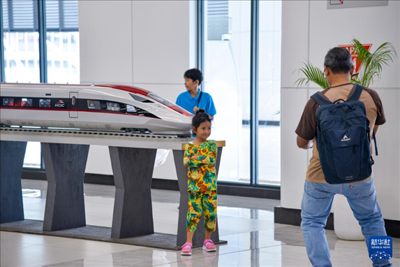 1月24日，在印度尼西亞雅加達(dá)哈利姆站候車大廳，一名小朋友和雅萬高鐵高速動(dòng)車組模型合影。新華社記者 徐欽 攝