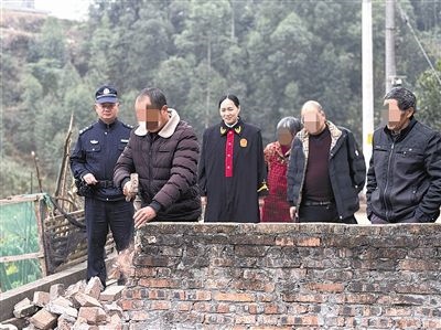  圖③：庭審結束后，在法官的見證下，陳某在院壩邊重新開鑿一條通道。
