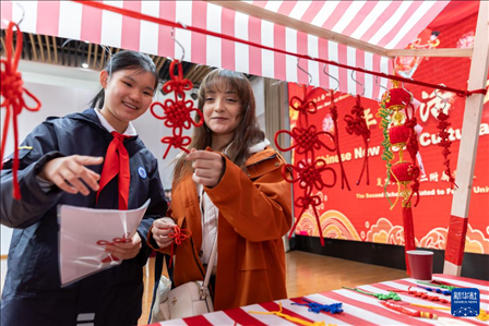 1月28日，復旦大學第二附屬學校學生（左）為美國馬斯卡廷中學學生（右）介紹中國結(jié)。 新華社記者 王翔 攝