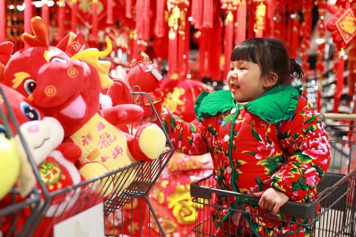 1月23日，在貴州省黔東南苗族侗族自治州岑鞏縣一家超市，小朋友在家人的帶領下選購龍年毛絨玩具。新華社發(fā)（唐鵬攝）