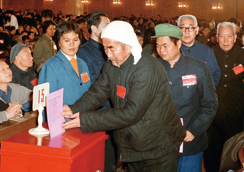我國現(xiàn)行憲法于1982年12月4日由第五屆全國人大第五次會議通過并公布施行。根據(jù)改革開放和社會主義現(xiàn)代化建設(shè)的實踐和發(fā)展，全國人大于1988年、1993年、1999年、2004年、2018年先后5次作出必要的、也是十分重要的修正。圖為出席第五屆全國人民代表大會第五次會議的代表投票表決《中華人民共和國憲法》（資料照片）。 新華社發(fā)