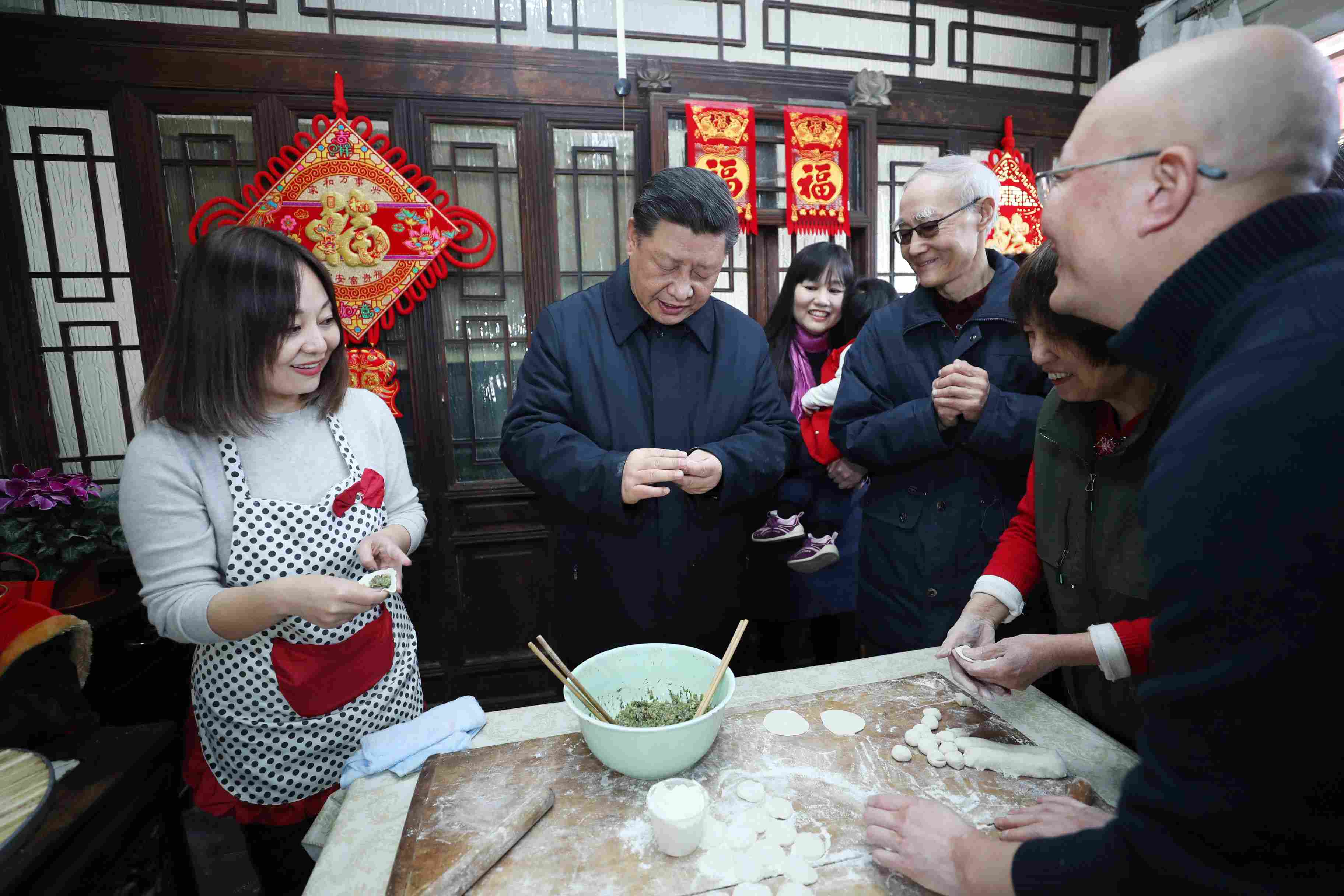 △ 2019年2月1日，習近平總書記在北京前門東區(qū)草廠四條胡同，同朱茂錦一家人包餃子、聊家常。