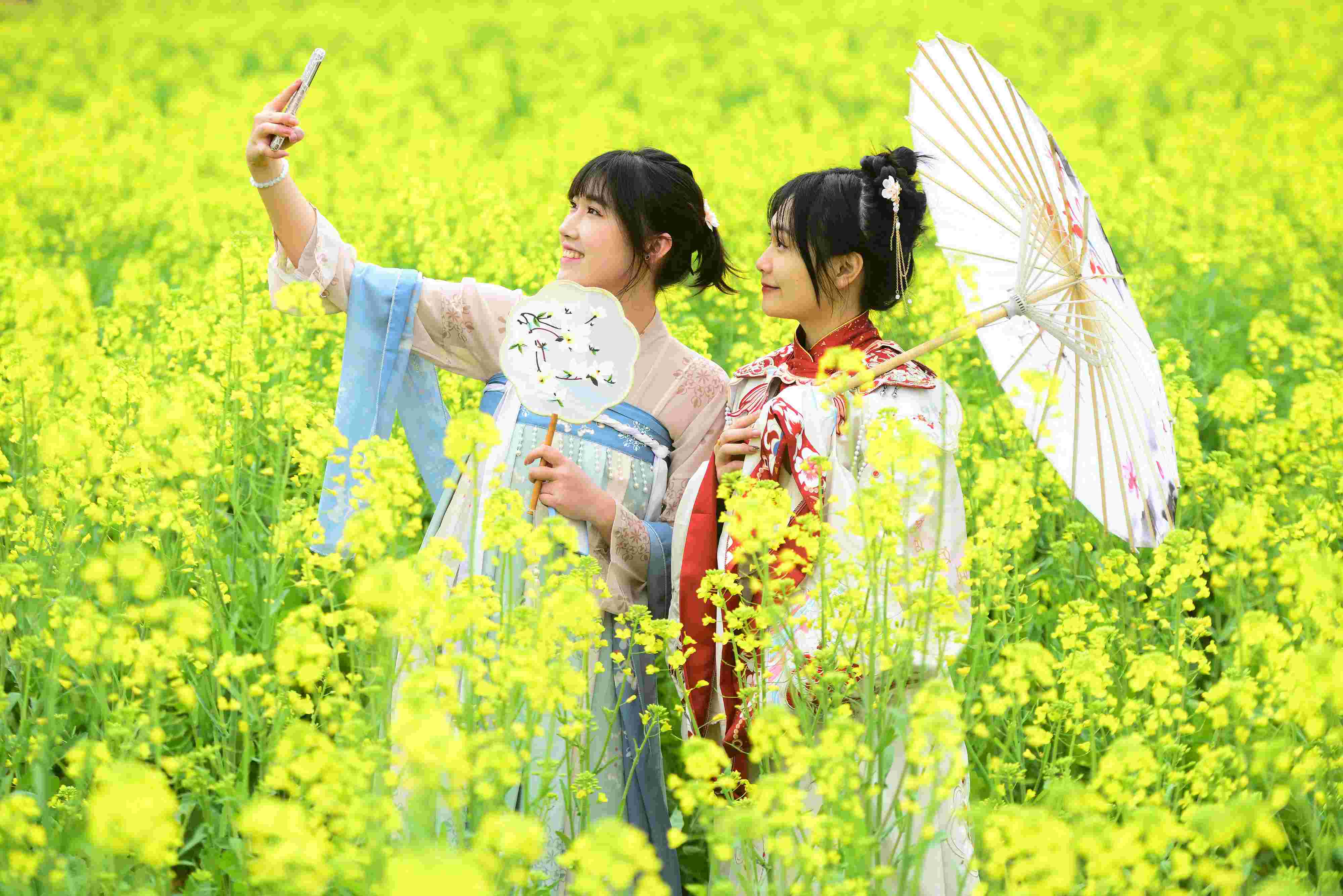 △ 2024年2月16日，廣西賀州，在富川瑤族自治縣麥嶺鎮(zhèn)三民村，游客在油菜花田間賞花拍照。