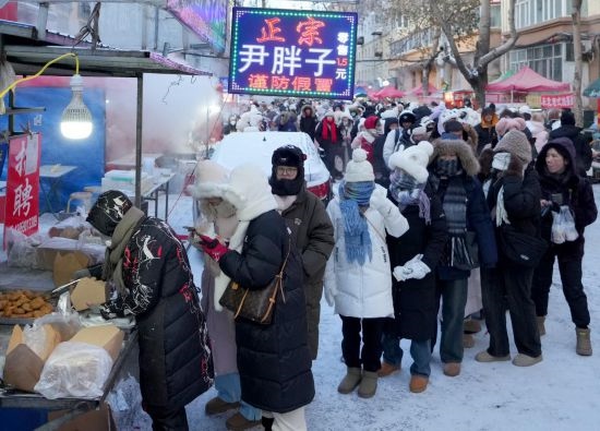 在哈爾濱紅專街早市，顧客們排起長隊購買油炸糕（1月22日攝）。新華社記者 王毓國 攝
