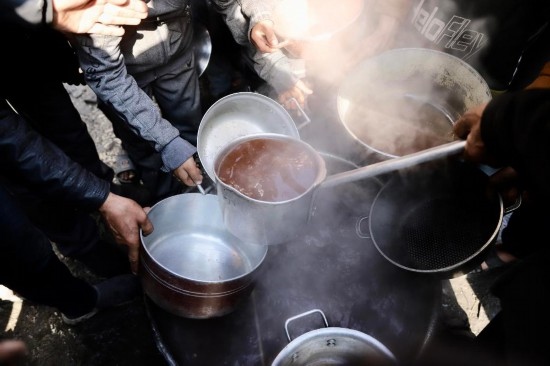  2月27日，在加沙地帶北部的杰巴利耶難民營，人們領(lǐng)取食物。新華社發(fā)（穆罕默德·阿里攝）