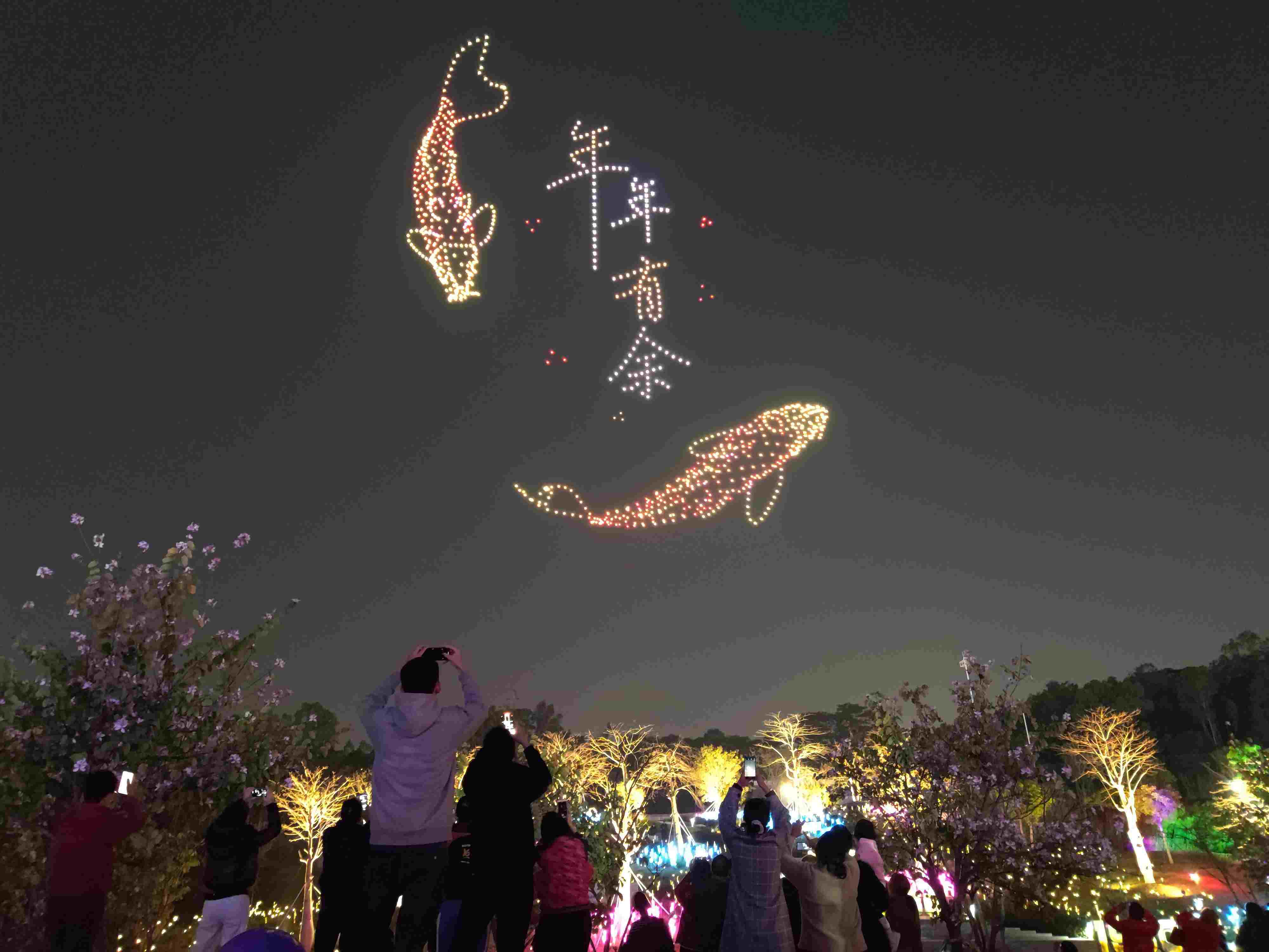 △ 2024年2月10日，深圳北站中心公園，春節(jié)主題無人機(jī)燈光秀引來眾多游客駐足觀看。