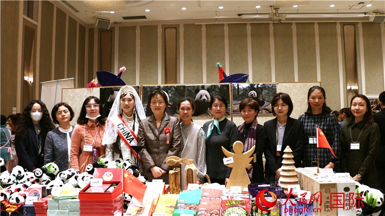 中國(guó)駐日本大使吳江浩夫人丁玥（左五）與使館人員在展位前合影留念。人民網(wǎng) 許可攝