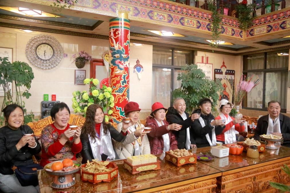 游客們?nèi)胱∶袼藓螅e杯共飲酥油茶。新華社記者 邱星翔 攝