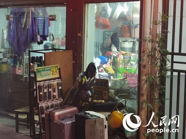 南寧“城中村”一裁縫鋪老板將電線從店內(nèi)拉出為電動自行車充電。人民網(wǎng) 覃心攝