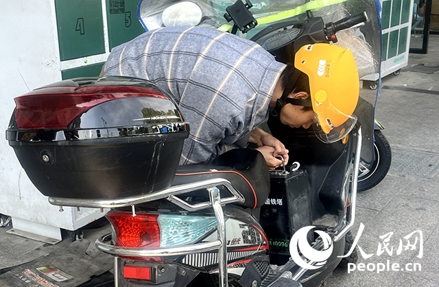 杭州一名外賣騎手正在更換共享電池。人民網(wǎng)記者 張麗瑋攝