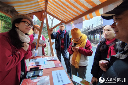 1月6日，“2024成都蒲江柑甜采摘節(jié)”上，記者見到了小萌（左一）和許多年輕人忙著做訪客接待、現(xiàn)場布置、票務(wù)核對、采摘服務(wù)等工作。人民網(wǎng)記者朱虹攝