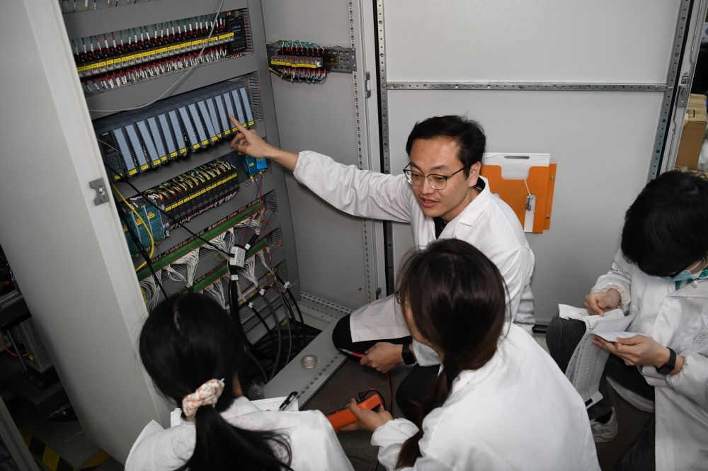 2024年4月6日，在位于安徽合肥的中國(guó)科學(xué)技術(shù)大學(xué)，安徽省先進(jìn)功能高分子薄膜工程實(shí)驗(yàn)室團(tuán)隊(duì)成員在檢修自主研制的高分子薄膜原位雙向拉伸實(shí)驗(yàn)設(shè)備的電氣控制系統(tǒng)。