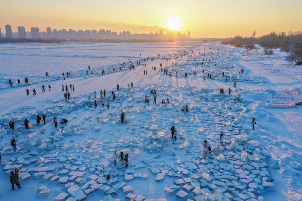 2024年1月7日，在封凍的松花江哈爾濱段，游客在日落時分的“鉆石?！庇瓮妫o人機(jī)照片）。新華社記者 謝劍飛 攝