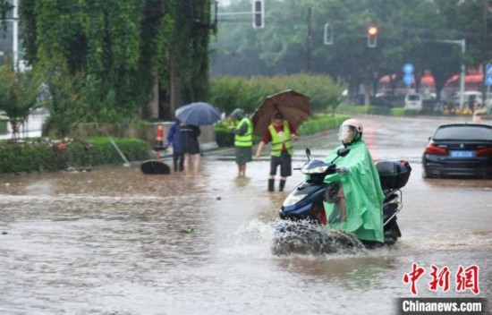 5月10日，廣西沿海遭遇強(qiáng)降雨。圖為欽州市民眾在積澇中出行。陸敏 攝