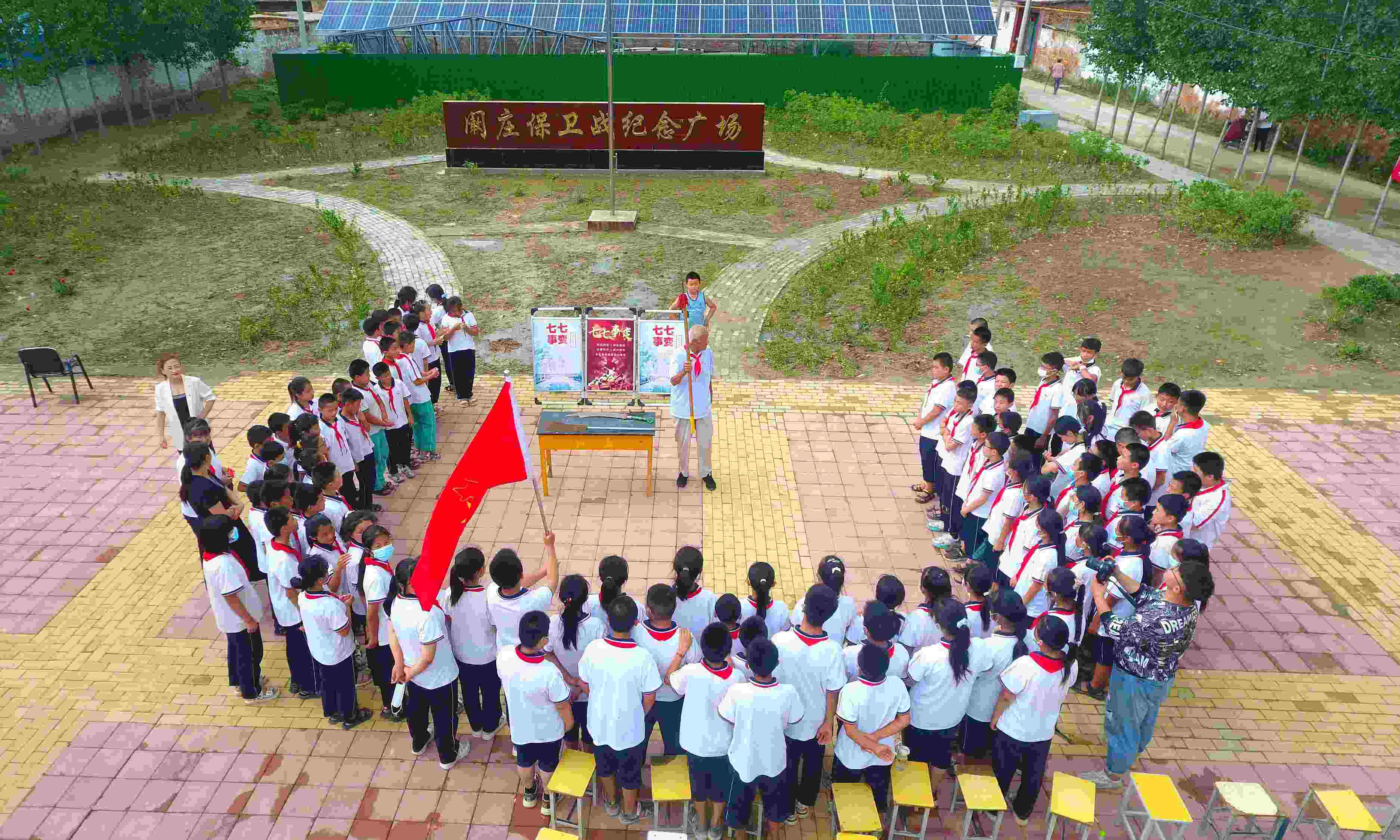 2022年7月6日，山東省聊城市，在茌平區(qū)菜屯鎮(zhèn)闞莊村的闞莊保衛(wèi)戰(zhàn)紀(jì)念廣場(chǎng)，闞莊保衛(wèi)戰(zhàn)親歷者王光木老人為小學(xué)生們講述抗戰(zhàn)故事，展示大刀、長(zhǎng)矛。