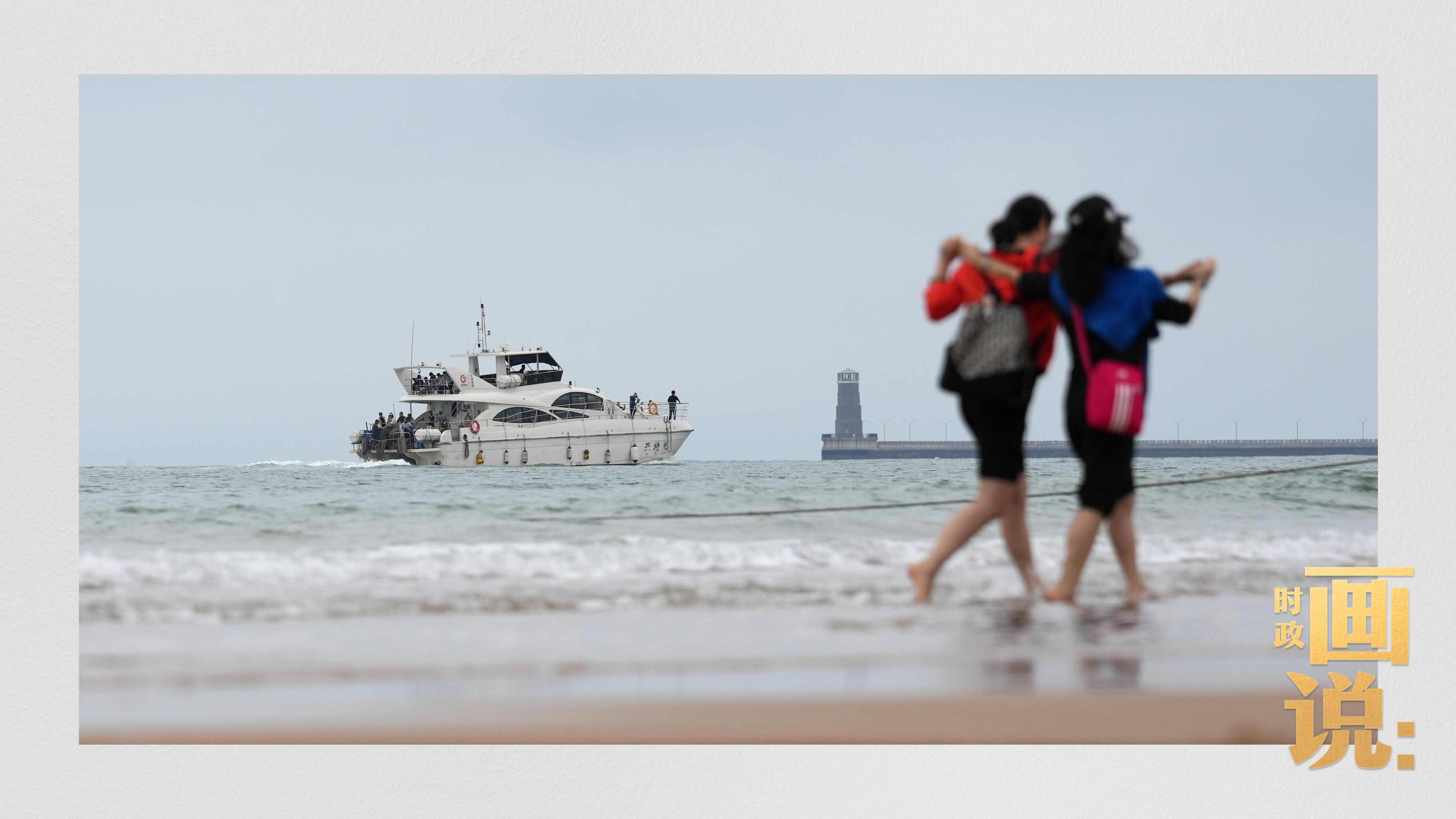△日照陽光海岸綠道上的萬平口景區(qū)，一對游客在海浪中翩然起舞。