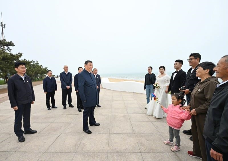 5月22日，在山東日照考察調(diào)研的習(xí)近平總書記來到陽光海岸綠道，同市民游客親切交流。