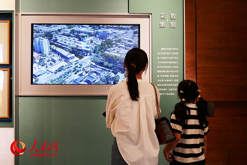 家長(zhǎng)正在帶孩子參觀“輝煌中軸”專題展。人民網(wǎng)記者 韋衍行攝