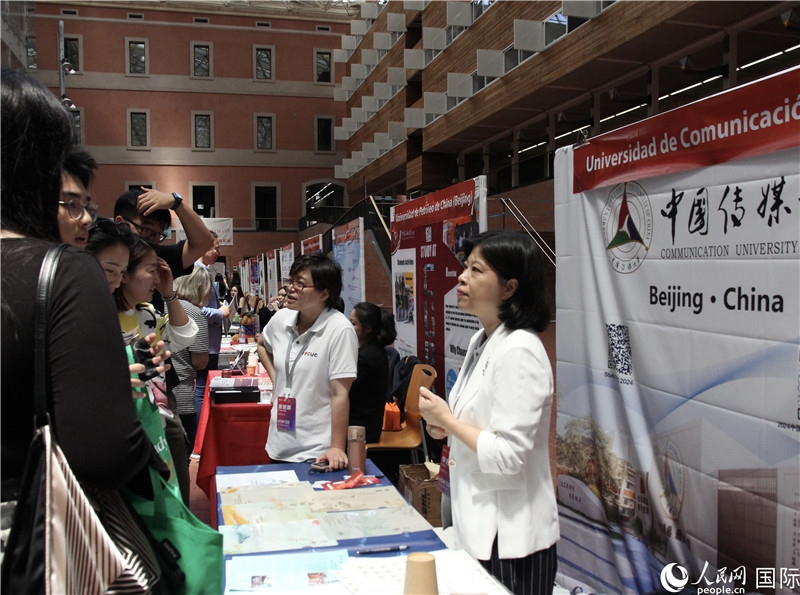 旅西華人華僑在展臺前咨詢。人民網(wǎng)記者 許海林?jǐn)z
