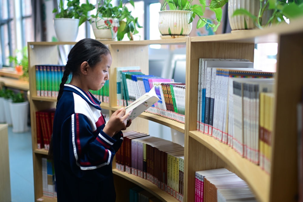 6月18日，果洛西寧民族中學(xué)學(xué)生尼東拉毛在圖書室看書。