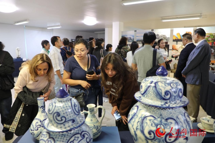 在展覽現(xiàn)場(chǎng)，觀眾們駐足欣賞德化瓷和墨西哥彩瓷。人民網(wǎng) 埃內(nèi)斯托·多明戈斯攝