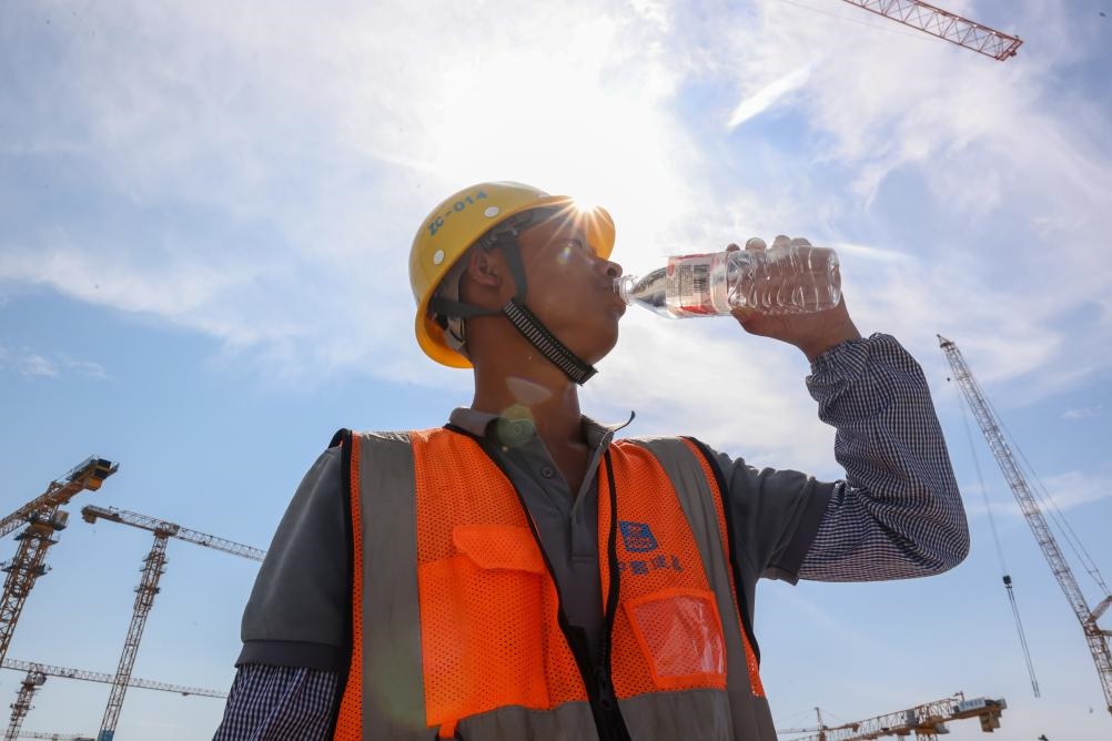6月18日，在江蘇省無錫市奧體三期項(xiàng)目施工現(xiàn)場，中建二局工人在喝水解暑。新華社發(fā)（朱吉鵬 攝）