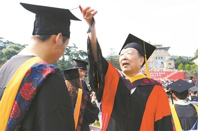 2017年6月22日，李德仁（右一）參加武漢大學(xué)畢業(yè)典禮并為畢業(yè)生撥穗。