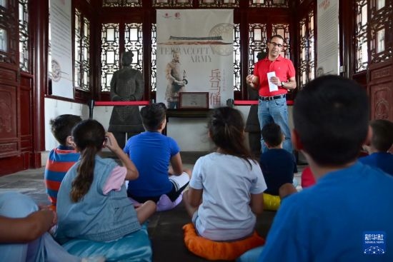 7月4日，在馬耳他桑塔露琪亞市的中國古典園林“靜園”，人們聆聽關(guān)于兵馬俑的講解。新華社發(fā)（喬納森·博格 攝）