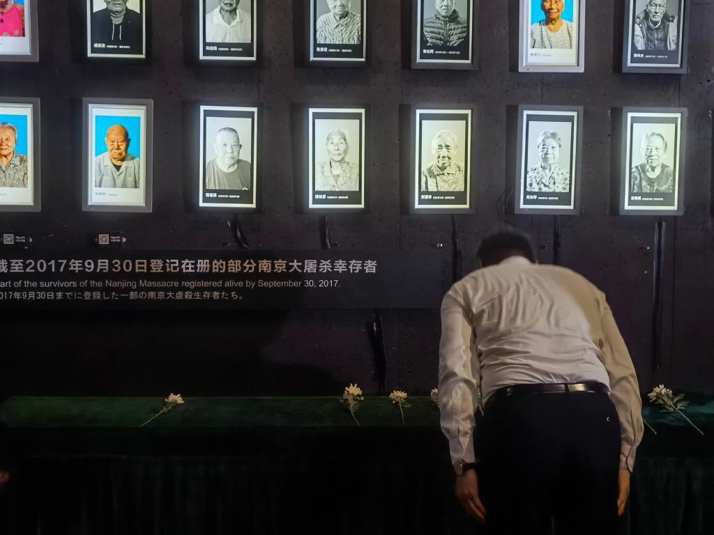 7月18日，人們向離世的南京大屠殺幸存者獻(xiàn)花、鞠躬。新華社記者邱冰清 攝