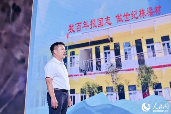 張玉滾分享用一根扁擔(dān)送孩子們走出大山的故事。人民網(wǎng)攝