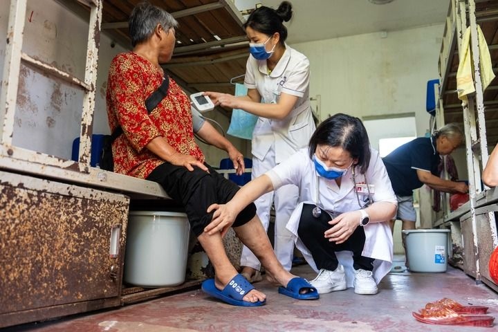 2024年7月30日，在湖南省湘潭縣河口中學(xué)安置點(diǎn)，醫(yī)務(wù)人員為受洪水影響而轉(zhuǎn)移安置的群眾檢查身體。 新華社記者 陳思汗 攝