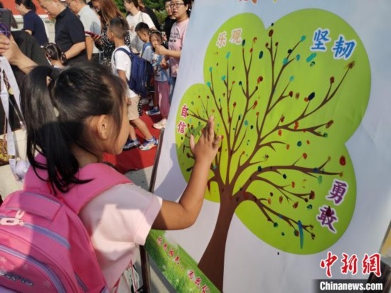 圖為衡水市利民路小學(xué)，孩子們?cè)诔砷L樹的“好習(xí)慣”樹枝上按手印做出承諾。張松 攝