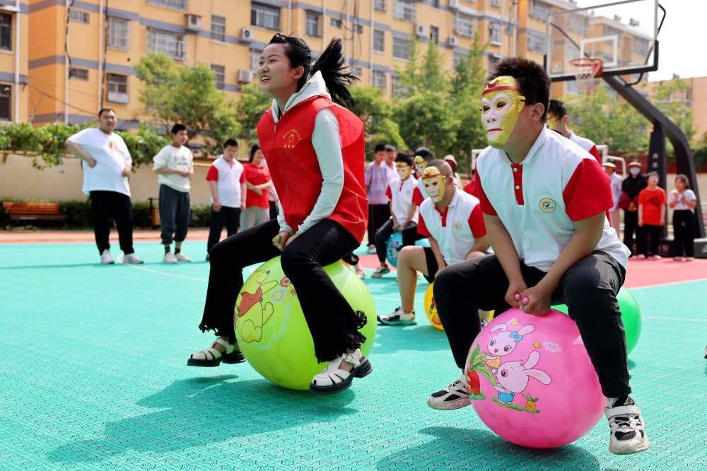 2024年5月17日，在山東省棗莊市市中區(qū)特殊教育中心，青年志愿者與智力障礙學(xué)生一起做游戲。新華社發(fā)（孫中喆攝）