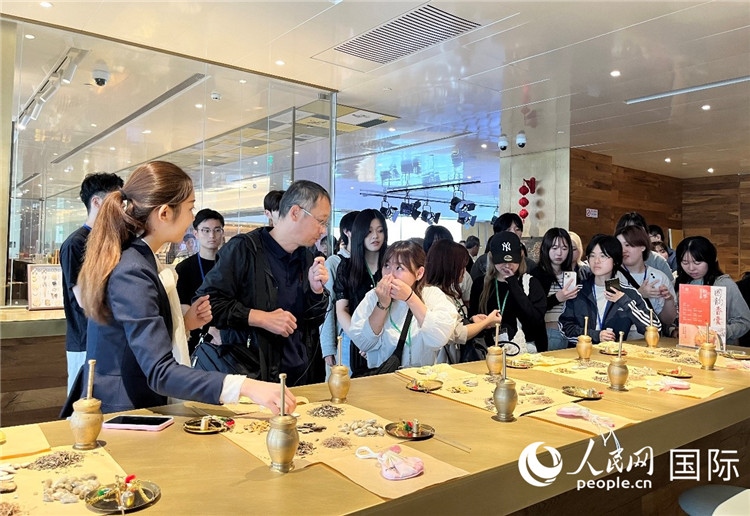 1. 日中友好協(xié)會(huì)青年代表團(tuán)一行學(xué)習(xí)中醫(yī)香囊制作工序。（人民網(wǎng)記者陳思 攝）