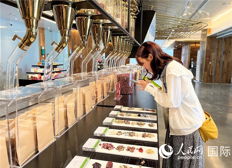 4. 代表團(tuán)團(tuán)員對(duì)新中式茶飲的食材充滿興趣。（人民網(wǎng)記者陳思 攝）
