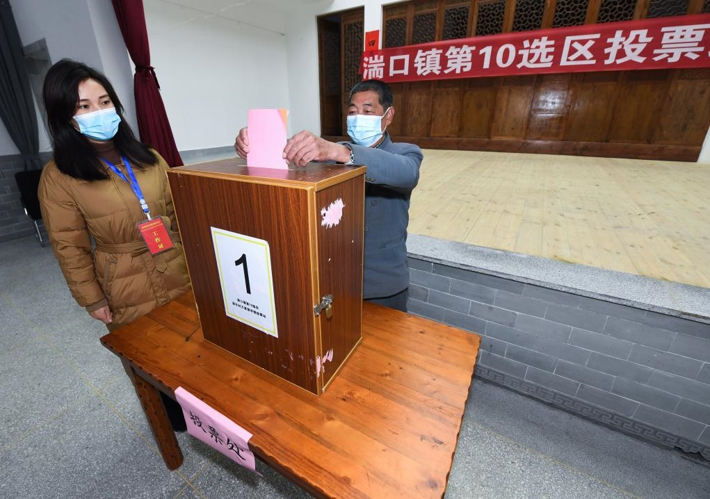 2021年12月14日，在浙江省杭州市臨安區(qū)湍口鎮(zhèn)迎豐村的基層投票點，村民在參加投票，村級監(jiān)察聯(lián)絡(luò)員監(jiān)票。新華社記者 徐昱 攝