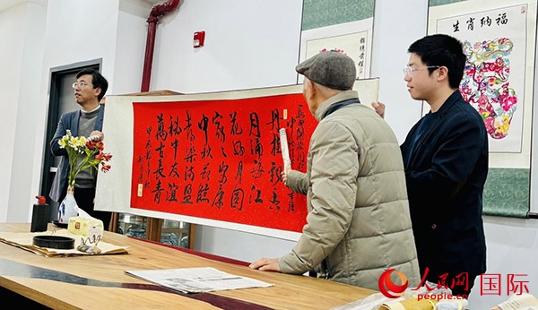 旅秘書法家向現(xiàn)場觀眾展示書法作品。人民網(wǎng)記者 宋亦然攝