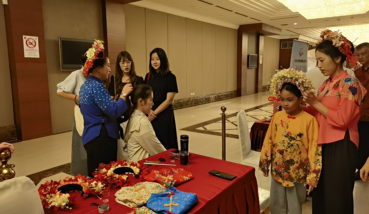 阿拉扎大學(xué)孔子學(xué)院志愿者老師向傳承人學(xué)習(xí)簪花圍。阿拉扎大學(xué)孔子學(xué)院供圖