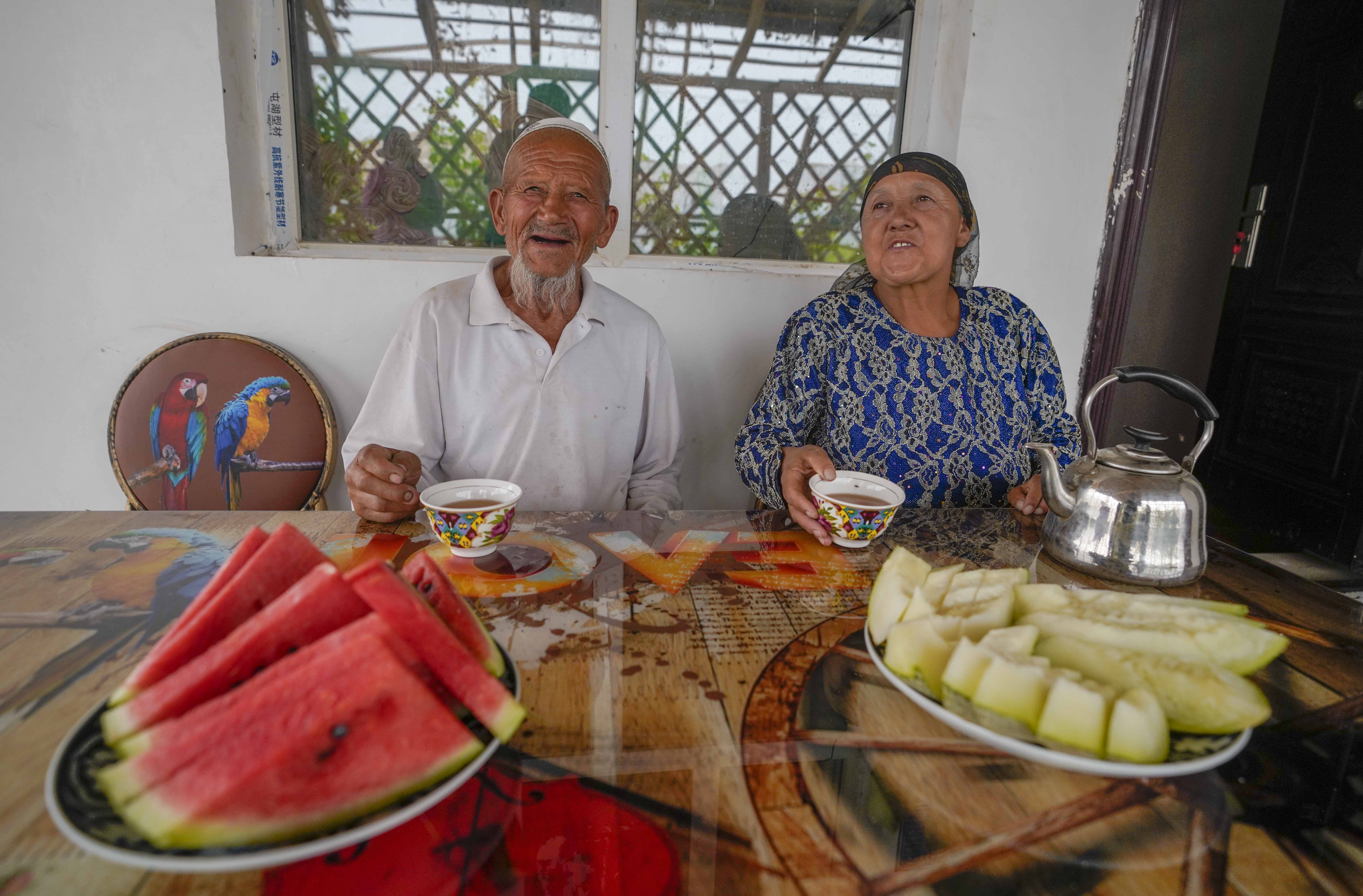 在新疆喀什地區(qū)伽師縣江巴孜鄉(xiāng)依帕克其村57號，80歲的維吾爾族老人伊米提·艾山（左）在自家庭院中（2020年6月8日攝）。