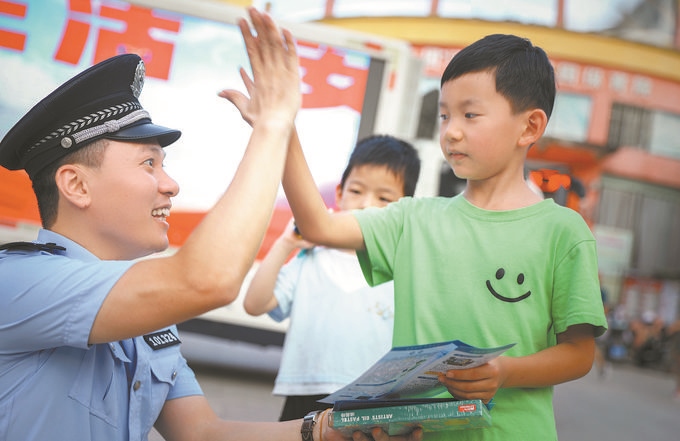 ▲7月10日，江西省吉安市公安局吉州分局組織民警深入轄區(qū)開展安全宣傳，民警向小朋友講解防溺水知識。朱文杰攝