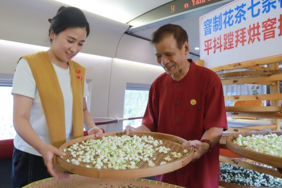10月1日，福州市茉莉花茶窨制工藝代表性傳承人張子建與旅客在G1634次列車上制作茉莉花茶。新華社記者周義 攝