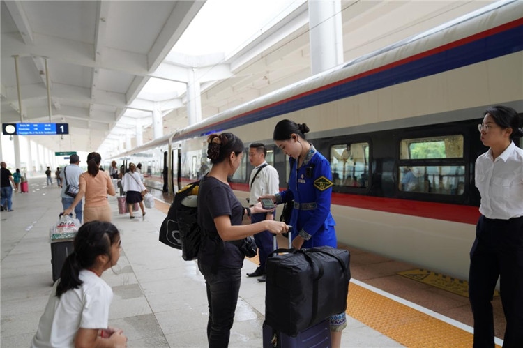 中老鐵路工作人員在站臺指引旅客進站乘車。老中鐵路有限公司供圖