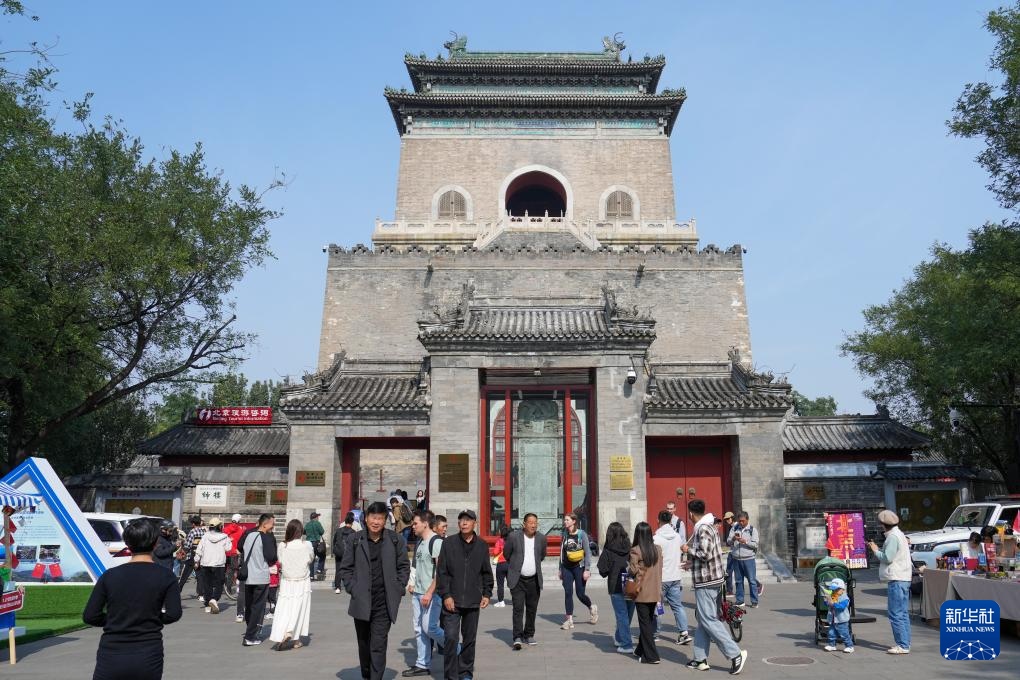 國(guó)慶假期，中外游客在北京鐘樓前參觀游覽。新華社記者 鞠煥宗攝